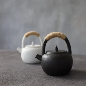 Full side view of matte black Japanese ceramic teapot with jute wrapped handle