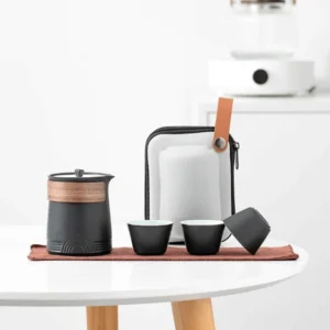 Full black portable ceramic chawan travel tea set with wooden handle on wood table