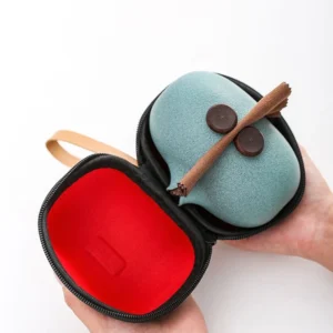 Open hard carrying case showing celadon green ceramic travel chawan tea set with red flocked lining