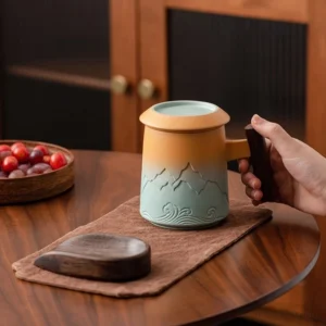 ceramic tea infuser mug with lid and wood handle mountain relief front view