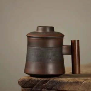 Full view of dark brown ceramic tea mug with infuser and wooden handle