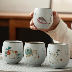 Hand painted cute cat Chinese ceramic tea cup on wooden tea table