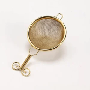 gold copper fine mesh handheld matcha sifter on white background