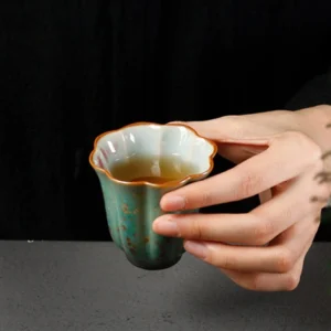 close-up green speckled porcelain lotus tea cup with golden speckle glaze