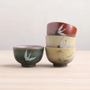 Collection of 3oz hand-painted ceramic Chinese tea bowls with traditional motifs, different glaze colors displayed