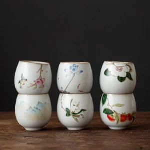 Collection of nine hand-painted traditional Chinese ceramic tea bowls with different nature motifs