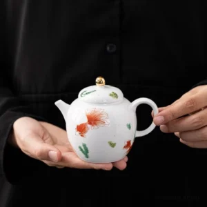 Hand-painted red goldfish pattern chinese porcelain teapot on wooden background, full product view