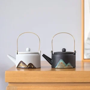 Hand painted mountain porcelain teapot with golden metal handle overall view