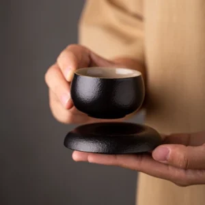 Japanese black clay textured tea cup with matching saucer full product view