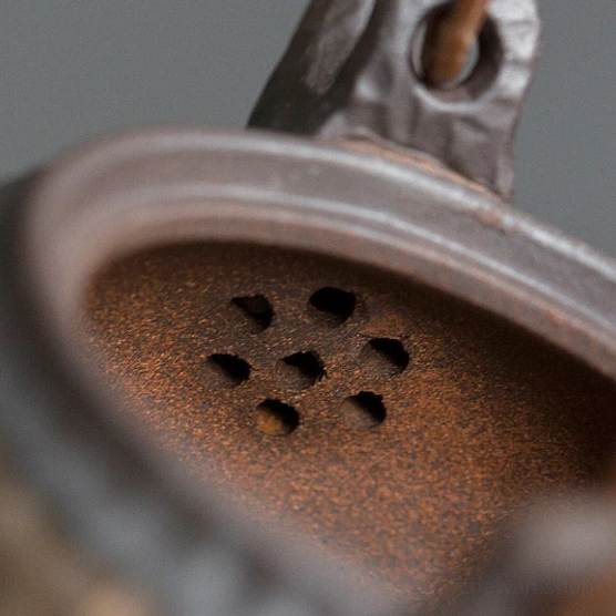 Close up of built-in integrated ceramic filter inside vintage Japanese hand hammered teapot